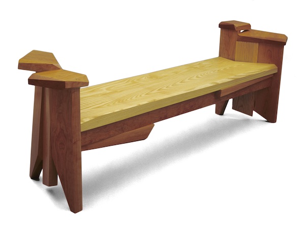 Cherry and ash bench with sculptural legs that have unusual arm rests