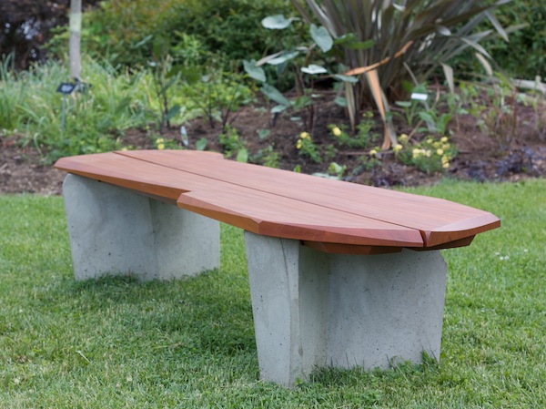 Assymetrical bench with concrete legs and water shedding seat