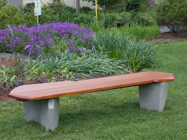 Assymetrical bench with concrete legs and water shedding seat