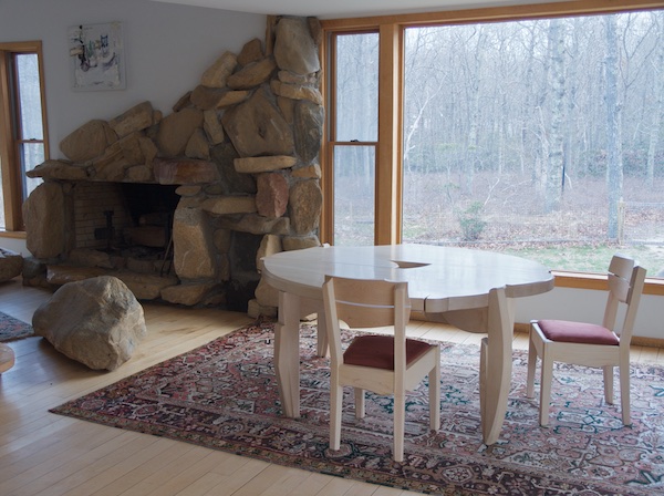 dining scene with rugged fireplace and dynamic circular table with equally dynamic chair
